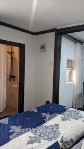 - une chambre avec un lit et une couette bleue dans l'établissement Da White Residence Makerere, à Kampala