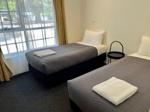 a hotel room with two beds and a window at Bright Avenue Motor Inn in Bright