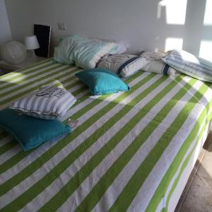 un letto verde e bianco con cuscini sopra di Argentario nice dreams a Porto Santo Stefano