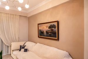 una sala de estar con sofá y una pintura en la pared en Cozy Cloud Apartment Nafplio, en Nauplia