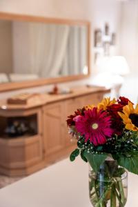 un jarrón lleno de flores sentado en una mesa en Cozy Cloud Apartment Nafplio, en Nauplia