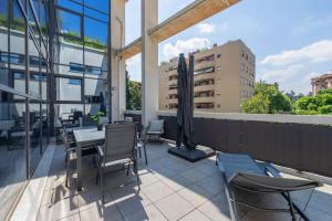 um pátio com uma mesa e cadeiras numa varanda em Spa Privata Luxury Apartment 5stelle-Free Parking em Monza