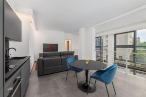 uma sala de estar com uma mesa e cadeiras azuis em Spa Privata Luxury Apartment 5stelle-Free Parking em Monza