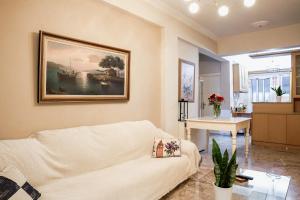 una sala de estar con sofá y una pintura en la pared en Cozy Cloud Apartment Nafplio, en Nauplia