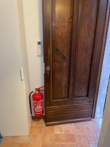 um hidrante sentado ao lado de uma porta de madeira em LA CASA DI ZOE em Campiglia Marittima