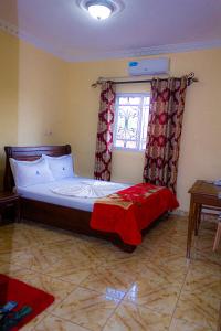 1 dormitorio con 1 cama grande y ventana en DF HOTEL plazza, en Yaoundé