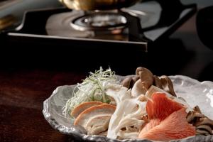 a plate of food with meat and vegetables on a table at Sui Suwako in Suwa