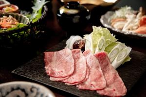 a plate of food with meat and vegetables on a table at Sui Suwako in Suwa