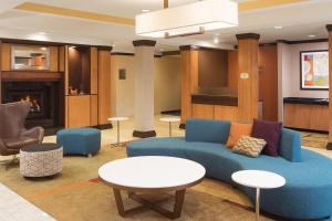 a lobby with a blue couch and a table and chairs at Fairfield Inn and Suites by Marriott Conway in Conway