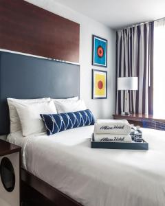 een slaapkamer met een groot wit bed met blauwe kussens bij Albion Hotel in Miami Beach