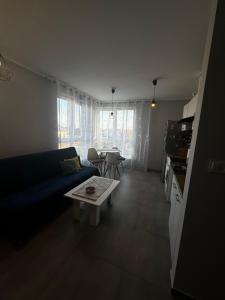 salon z niebieską kanapą i stołem w obiekcie Apartament Kosakowo obok Gdyni w mieście Kosakowo