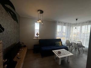 uma sala de estar com um sofá azul e uma mesa em Apartament Kosakowo obok Gdyni em Kosakowo