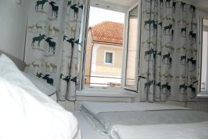 Schlafzimmer mit einem Bett und einem Fenster mit Vorhängen in der Unterkunft La Gondola in Niederneukirchen