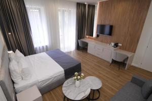 una camera d'albergo con letto, scrivania e TV di Ser In Hotel a Yerevan