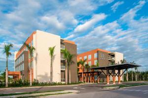 un bâtiment avec des palmiers à côté d'une rue dans l'établissement Four Points by Sheraton , à Punta Cana