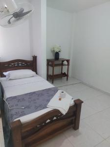 una camera da letto con un letto e un asciugamano sopra di HOSTAL CARACOLI - HUECO a Valledupar