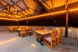 a restaurant with wooden tables and chairs on a balcony at Treebo Green Village Resort - Goa in Maneri