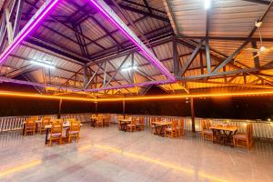 a dining room with wooden tables and chairs at Treebo Green Village Resort - Goa in Maneri