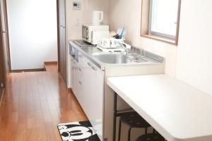 een keuken met een wastafel en een magnetron bij Chiba - House - Vacation STAY 87410 in Chiba