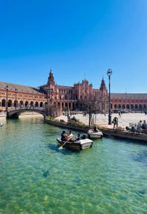 zwei Boote in einem Fluss vor einem Gebäude in der Unterkunft Libertad B in Santiponce