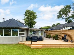 a house with a wooden deck with chairs on it at Two-Bedroom Holiday home in Aabenraa 2 in Aabenraa