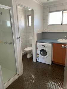 ein Badezimmer mit einer Waschmaschine und einem WC in der Unterkunft Whitehaven Beachfront Holiday Units in Airlie Beach