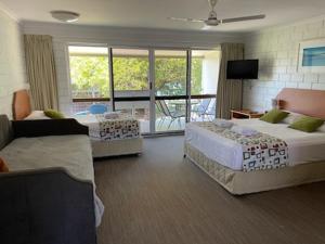 ein Hotelzimmer mit 2 Betten und einem Balkon in der Unterkunft Whitehaven Beachfront Holiday Units in Airlie Beach