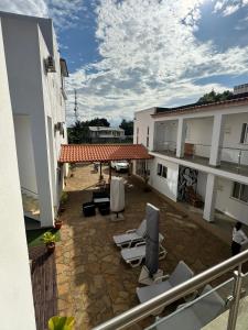 d'une terrasse avec des chaises et une télévision sur un balcon. dans l'établissement Hotel Kenito, à São Tomé