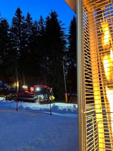 un camion neige est garé dans la neige la nuit dans l'établissement STENATA Sport Apartments, à Pamporovo