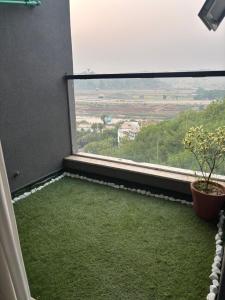 Zimmer mit einem großen Fenster mit grünem Gras in der Unterkunft Eiffel Tower Apartment in Rawalpindi