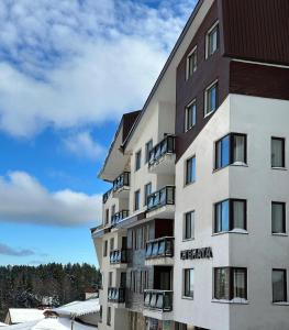 un immeuble avec de la neige au sol dans l'établissement STENATA Sport Apartments, à Pamporovo