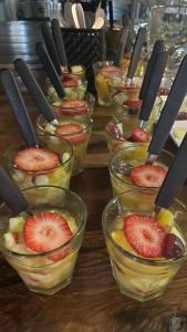 a bunch of bowls of fruit with tongs in them at Costalago Suites Hotel in Villa Carlos Paz