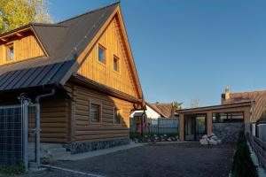 uma cabana de madeira com um telhado de metal e uma garagem em Kukana & Kuku em Vysoké Tatry