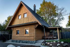 uma cabana de madeira com um telhado de gambrel em Kukana & Kuku em Vysoké Tatry