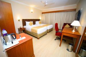 Habitación de hotel con cama y escritorio en Raj Park- Hill View, en Tirupati