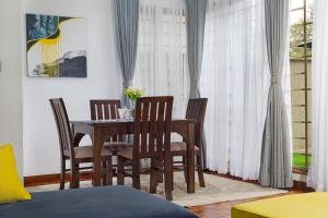 - une salle à manger avec une table et des chaises en bois dans l'établissement Tranquil Residences, à Nairobi