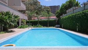 - une grande piscine d'eau bleue dans la cour dans l'établissement Tranquil Residences, à Nairobi