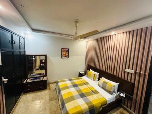 a bedroom with a bed with a checkered blanket at Seaview Lodge Guest House in Karachi