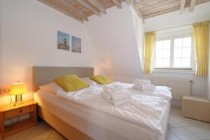 a bedroom with a bed with towels on it at Syltnest in Munkmarsch