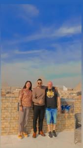 eine Gruppe von Menschen, die neben einer Mauer stehen in der Unterkunft desert pyramids view inn in Kairo