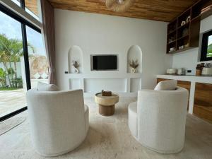 a living room with two white chairs and a tv at Tropical Pool Villa near Fishermans Village in Bophut 