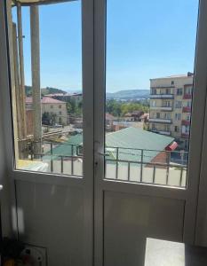 une porte donnant sur un balcon avec vue sur un bâtiment dans l'établissement Solar Convenience, à Akhaltsikhé