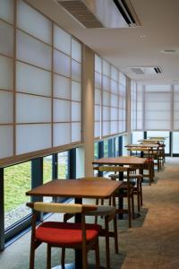 a row of tables and chairs in a room with windows at Shin-Osaka Station Hotel in Osaka