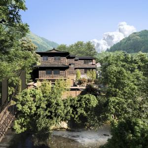 une maison au milieu d'une rivière avec des arbres dans l'établissement Ochiairo, à Izu