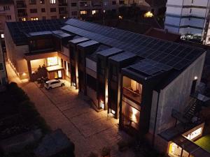 a house with solar panels on the roof at night at No Pardon Hotel in Satu Mare