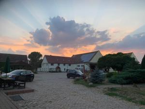 um edifício com carros estacionados num parque de estacionamento em Ruhiges Wohlfühlzimmer auf dem Pferdehof Gut Greppin - mit Kochnische, WLAN & kostenlosem Parken em Greppin