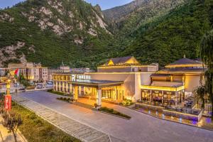 um hotel com uma montanha ao fundo em Qianhe Rezen Hotel em Jiuzhaigou