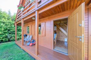 ein Haus mit einer Terrasse mit einem Roller drauf in der Unterkunft Pensjonat Kwiatkowski domek nr 3 in Nowęcin