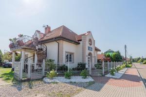 ein Haus mit einem weißen Zaun in der Unterkunft Pensjonat Kwiatkowski domek nr 3 in Nowęcin