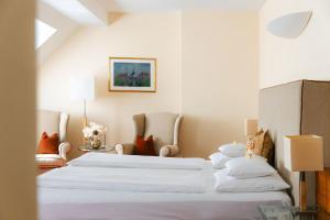 two beds in a room with white walls at Hotel Kaiserhof Wien in Vienna